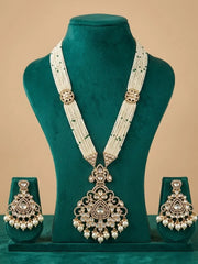 An ornate Indian traditional jewelry set displayed on a dark green velvet mannequin bust. The set includes a long multi-strand pearl necklace with a large central pendant, and two matching drop earrings, all decorated with gold-toned metalwork and clear stones.
