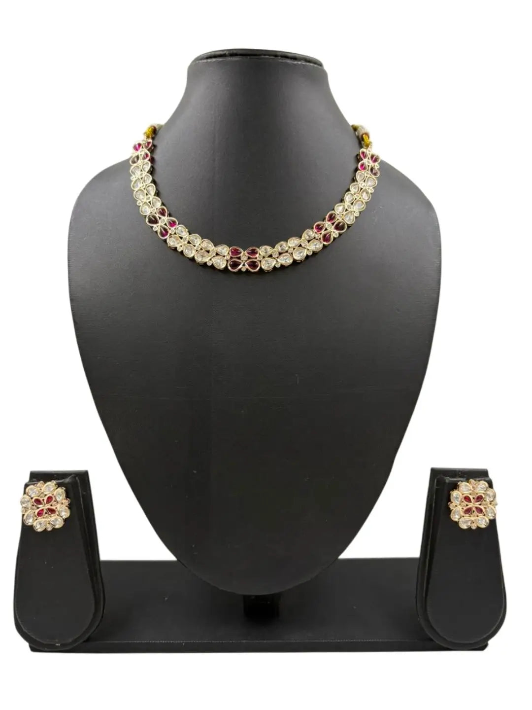 Necklace and earrings set on a black mannequin bust with a white background