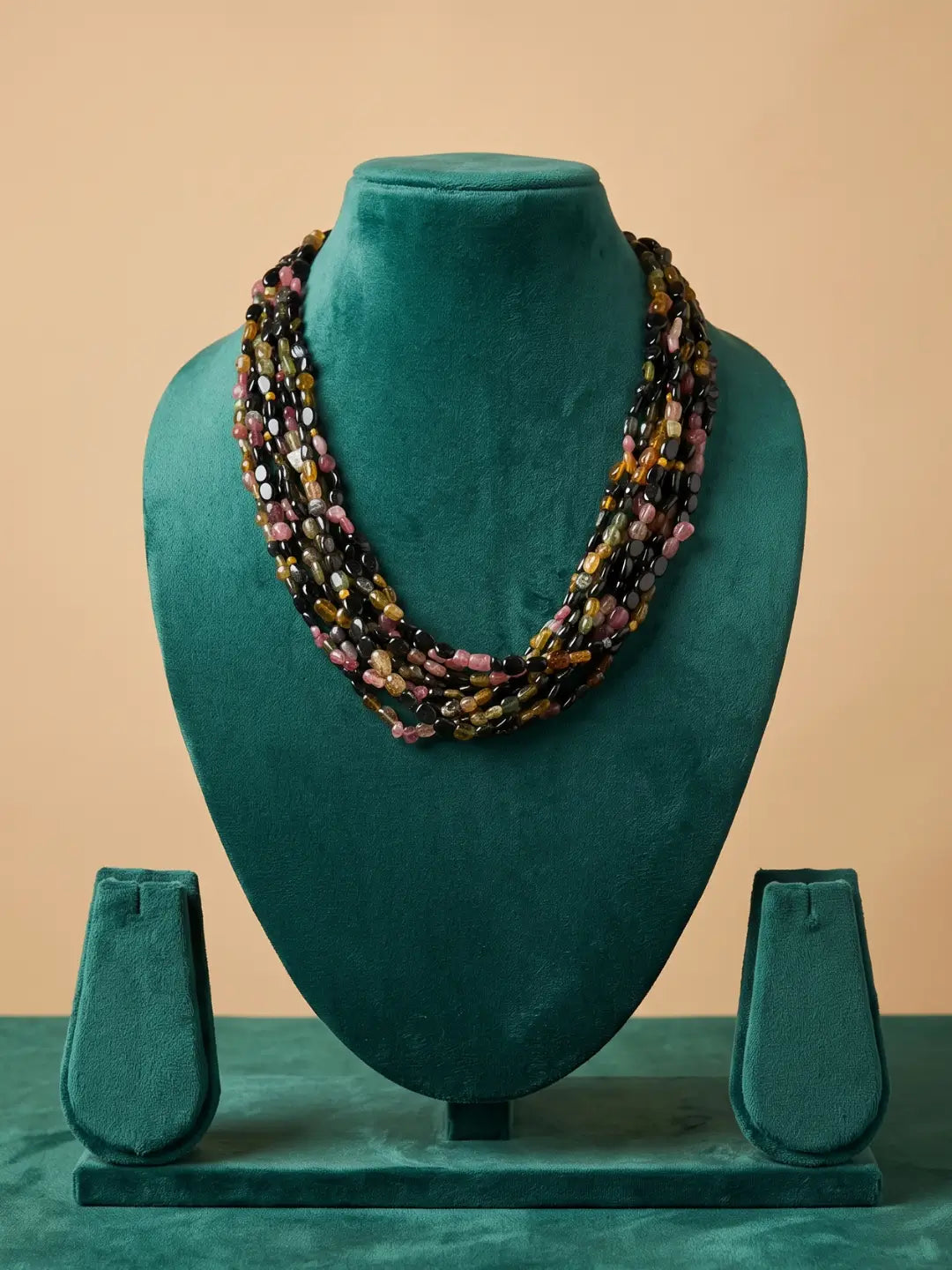 Back closure of a multi strand tourmaline beaded necklace showing the adjustable fastening where the layered gemstone strands meet