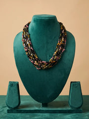 Back closure of a multi strand tourmaline beaded necklace showing the adjustable fastening where the layered gemstone strands meet