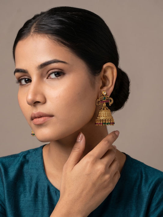 Antique gold Kundan Jhumka earrings with ruby and emerald accents, intricate filigree detailing and colourful bead tassels.