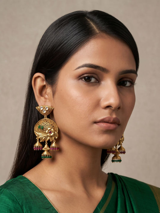 Antique gold Kundan Jhumka earrings with intricate filigree, floral detailing and green and ruby bead drops for traditional ethnic looks.