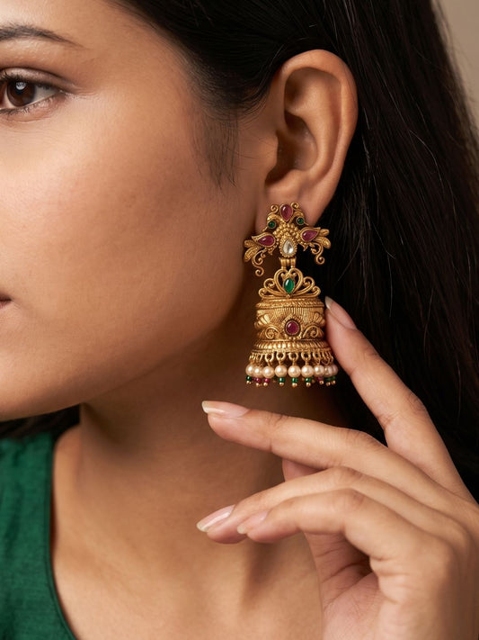 Antique gold Peacock Jhumka earrings with Kundan stones, peacock-inspired detailing, synthetic gemstones and pearl bead tassels.