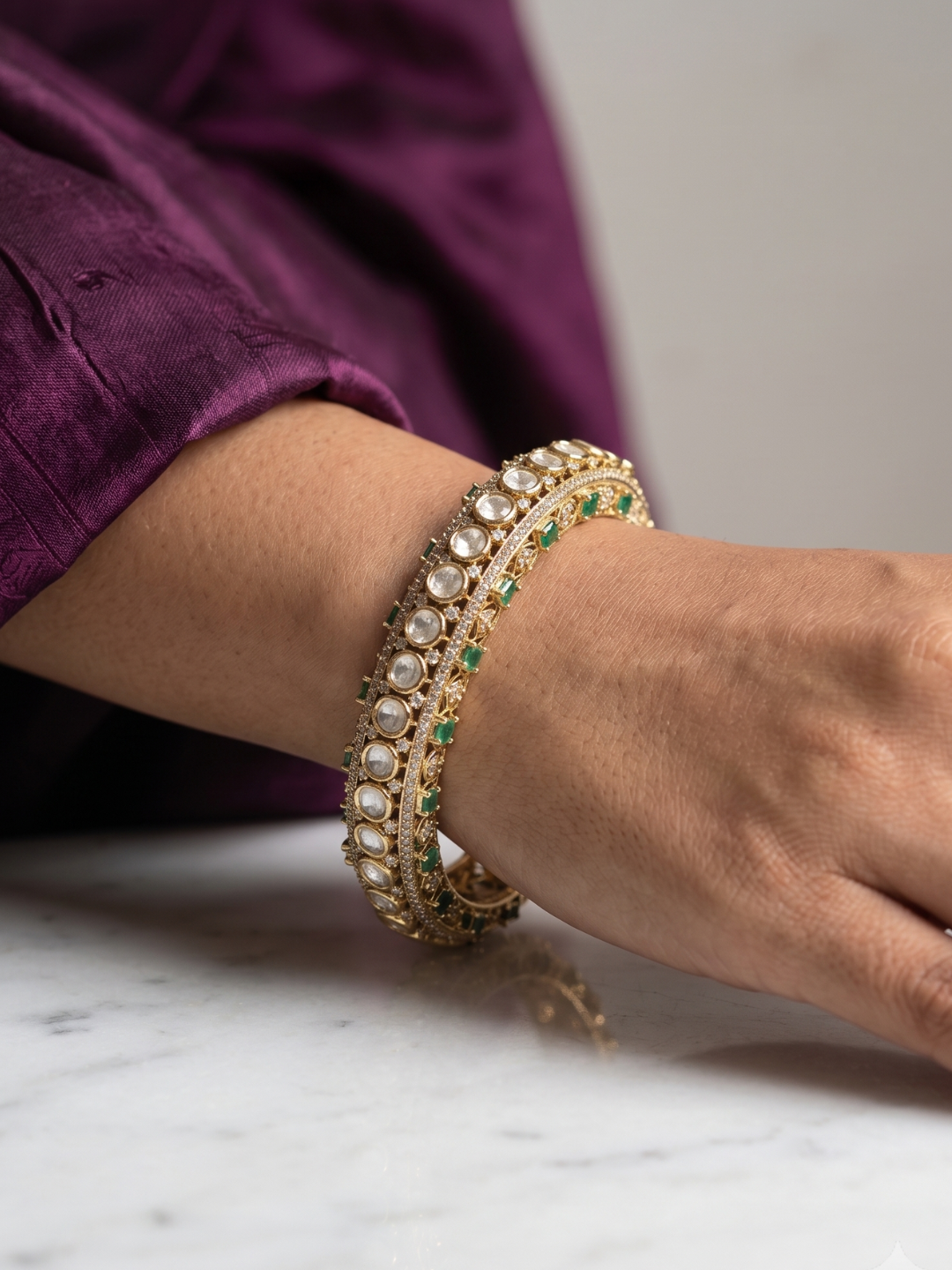 A close-up portrait of womens hand wearing Luxury Antique Victorian Polki Kada Bangles With Emerald Stones | Wedding & Bridal Kada Bangles