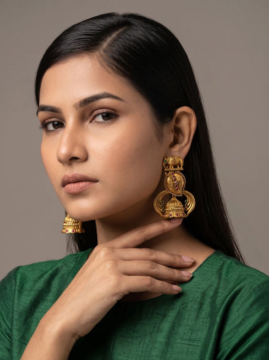 Antique gold temple jhumka earrings with an elephant motif, floral engravings, Kundan detailing and ruby and emerald-coloured accents