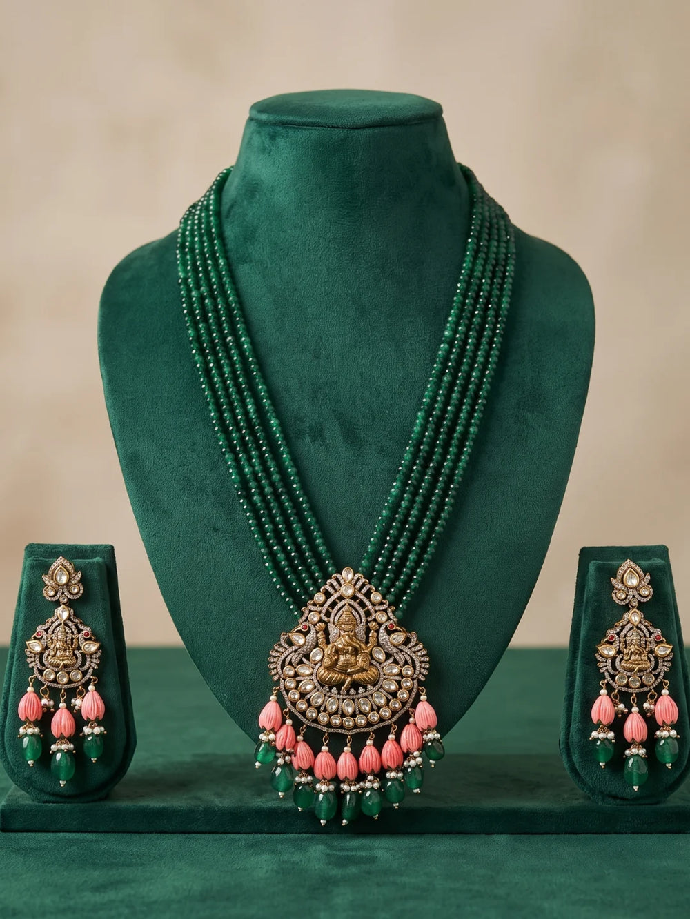 Green Ganesha necklace set with a decorative deity pendant, intricate stone embellishments, layered beads and coordinating earrings for traditional outfits.