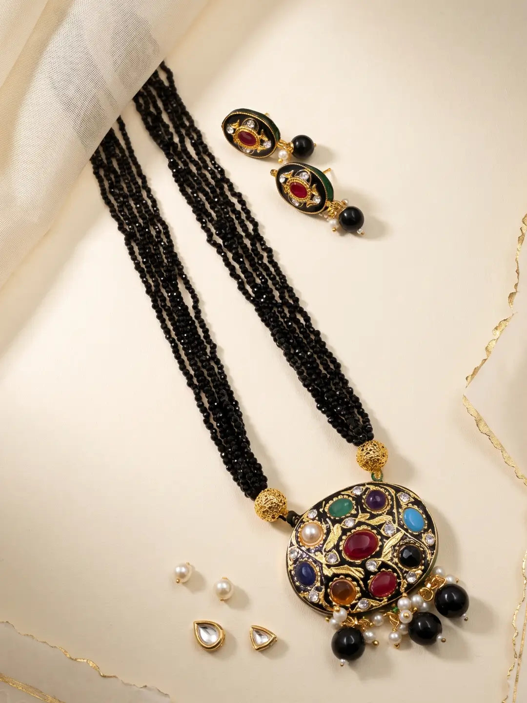  Black layered bead necklace with a Navratna Meenakari pendant, pearl accents and matching stud earrings.