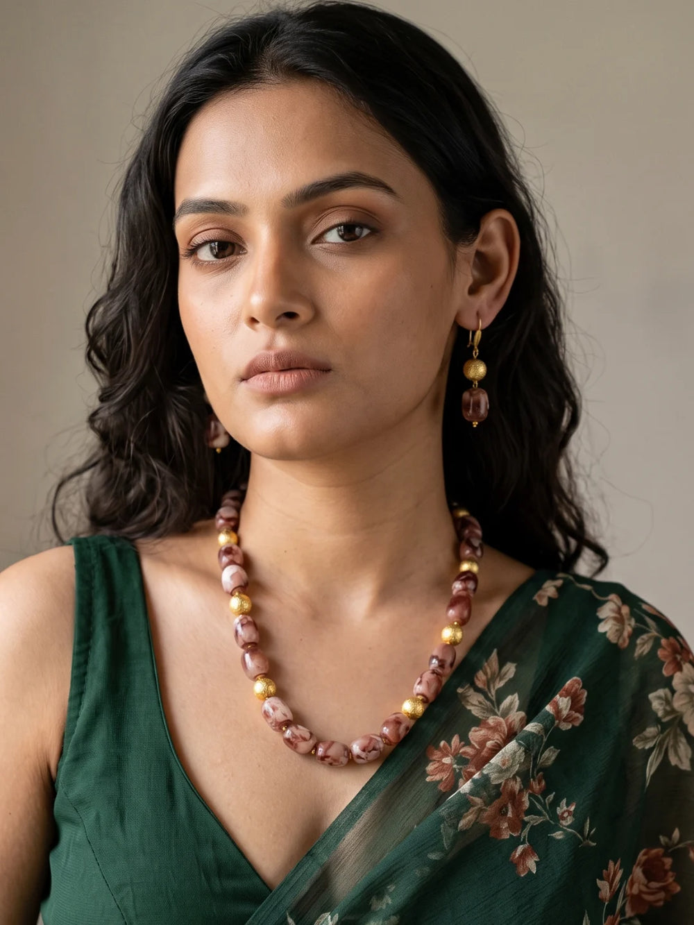Layered necklace of brown shaded chalcedony cylinder beads with gold-plated round spacer beads, laid out in a curve beside a pair of matching drop earrings