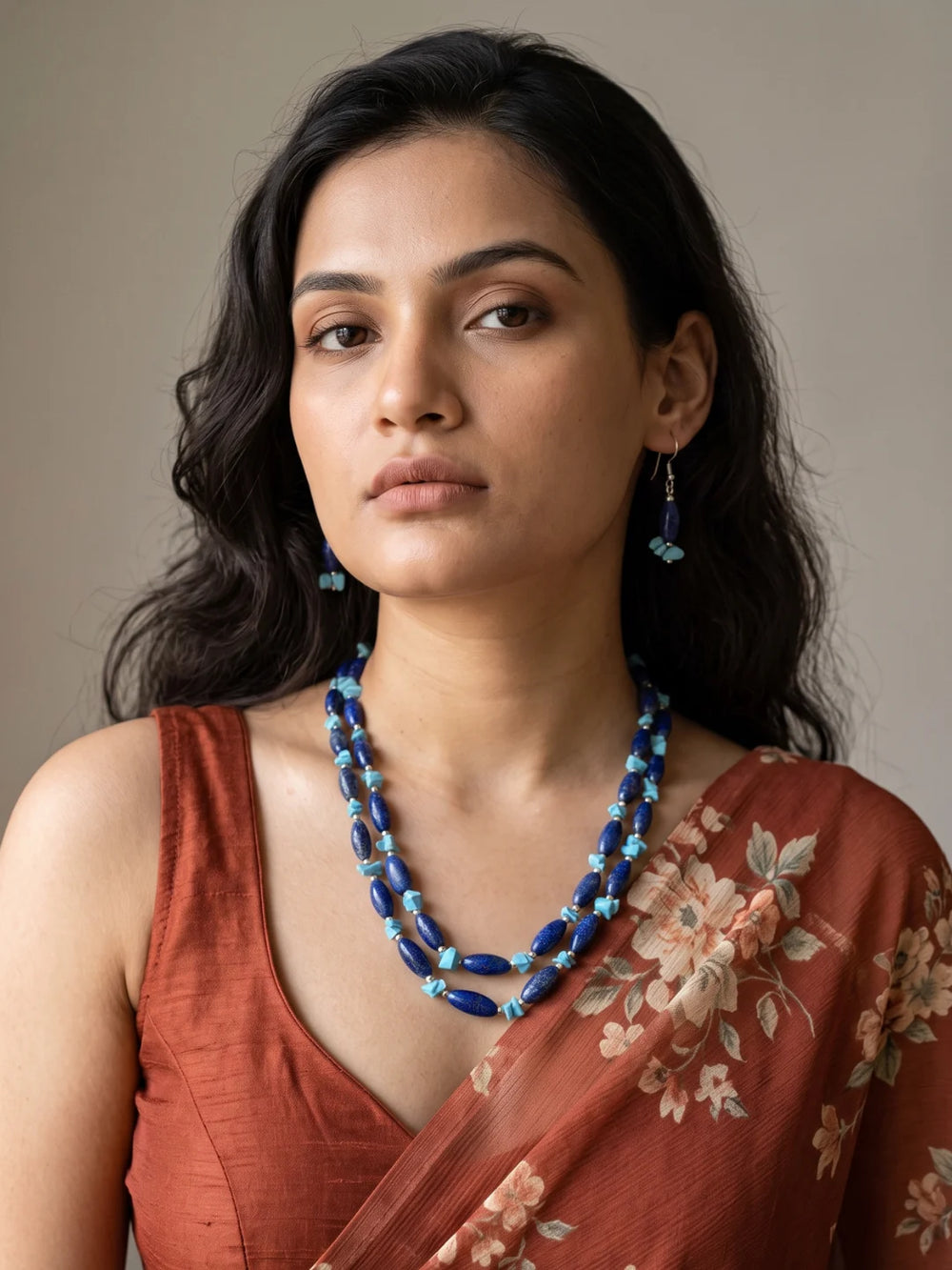 Close-up of elongated deep blue lapis lazuli beads alongside irregular bright turquoise chip beads and small silver-tone spacer beads on the strands