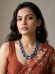 Close-up of elongated deep blue lapis lazuli beads alongside irregular bright turquoise chip beads and small silver-tone spacer beads on the strands