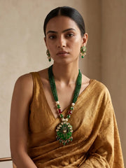 Detailed view of the green variant's peacock-inspired Meenakari pendant with red, green and blue enamel work and sparkling Kundan stone accents.