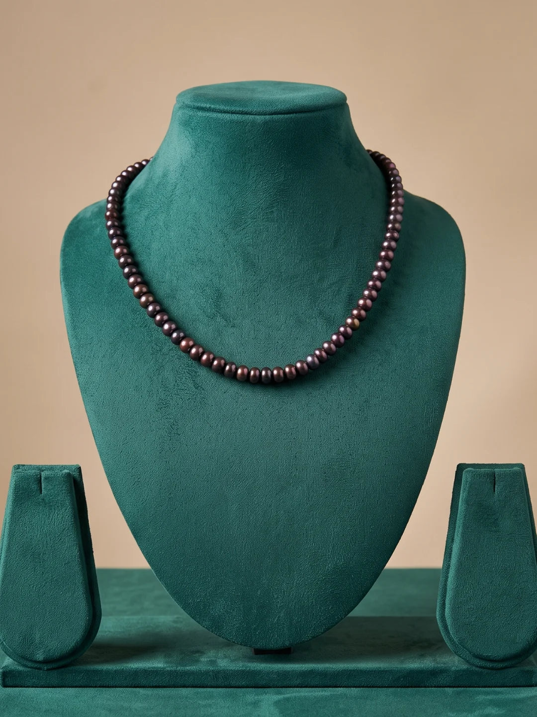 Close-up of glossy black and charcoal grey freshwater pearl beads showing a soft iridescent sheen along the strand of the necklace
