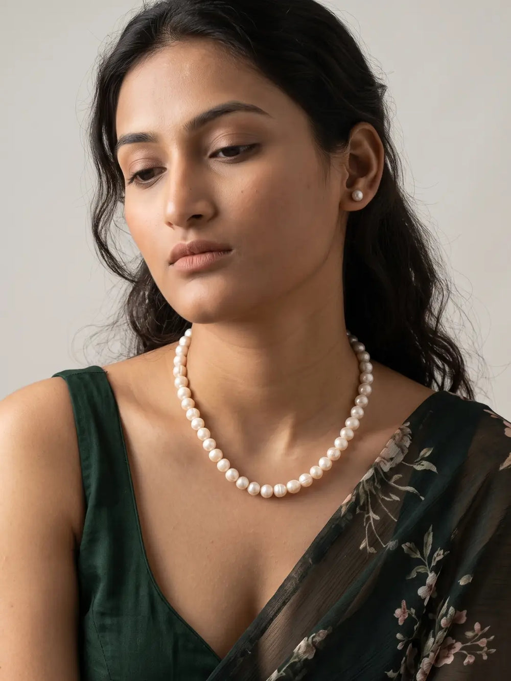 Close-up of evenly arranged round ivory-white freshwater pearl beads showing a smooth, polished finish and soft natural-looking sheen