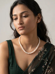 Close-up of evenly arranged round ivory-white freshwater pearl beads showing a smooth, polished finish and soft natural-looking sheen