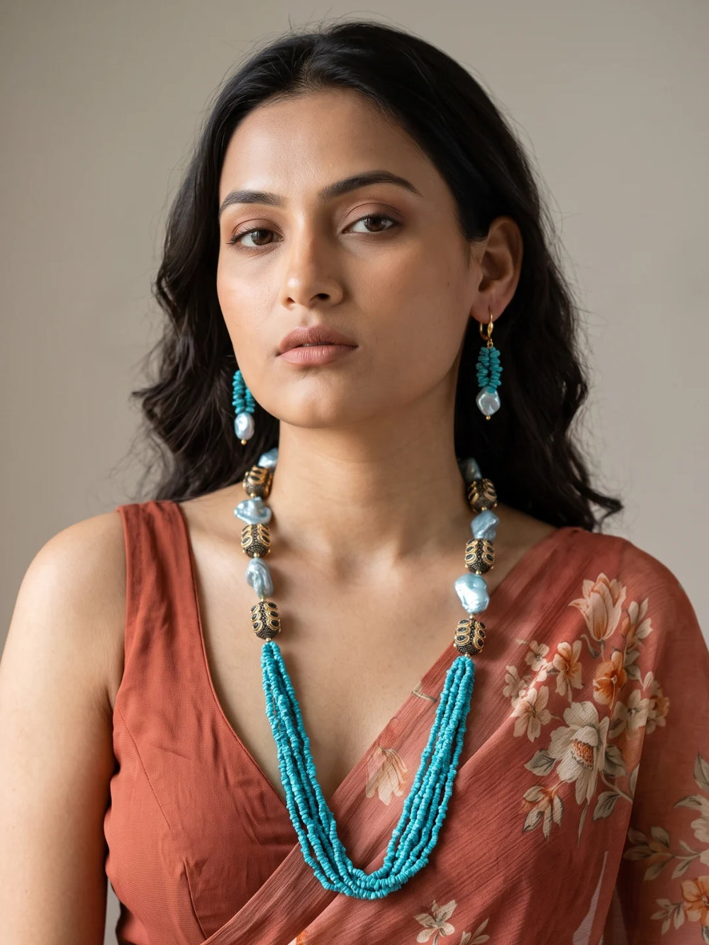 Close-up of vibrant turquoise chip beads and lustrous aqua-blue shell pearl beads arranged in cascading strands, showing their texture and colour