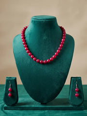 Close view of glossy cherry-red faceted round beads in 10 mm size with silver-tone accents on a single-strand necklace