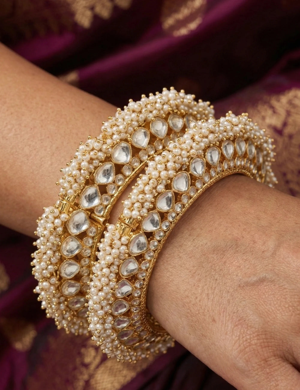 Close view of a gold plated jadau gokhru bangle showing paachi kundan work and pearls with a heritage touch in the design