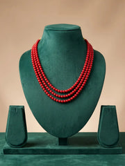 Close view of glossy polished red coral beads in rich red tones with elegant gold-tone end caps at the ends of the layered strands