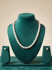 Gold-plated hook-and-eye closure and adjustable end of a white freshwater pearl necklace, shown beside the lustrous round pearl strand