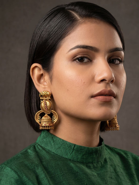Close-up of antique gold elephant temple earrings featuring ornate floral work, Kundan detailing and traditional jhumka bell danglers