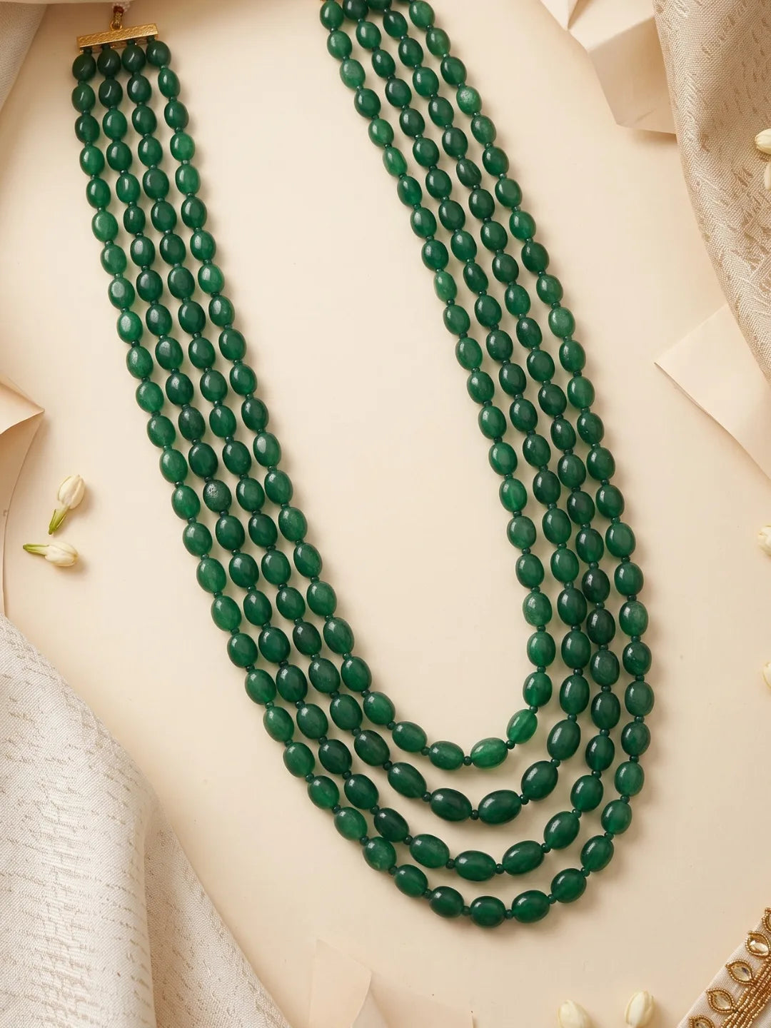 Gold-plated dulha mala with polished green jade beads arranged in cascading strands, creating a distinctive traditional accessory for Indian groom outfits.