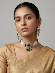 Woman wearing a gold saree with a dual-tone mossanite polki beaded choker with  green stones on a gray background