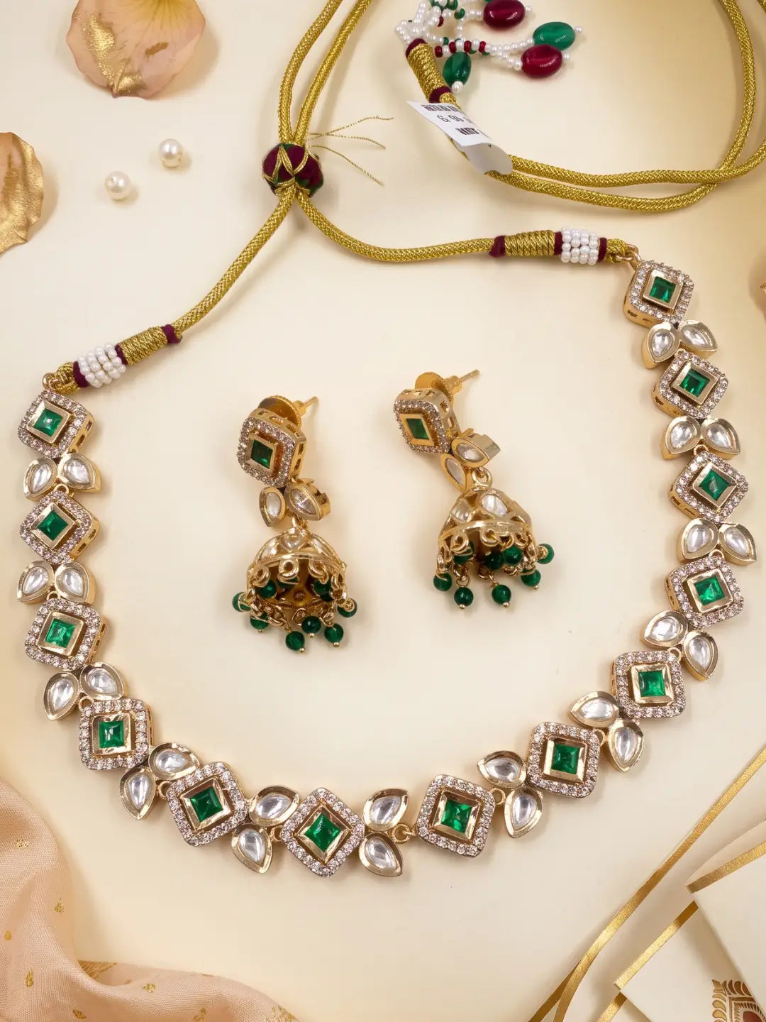 Emerald green Kundan choker set with matching Jhumka earrings, white Polki stones and intricate gold-tone detailing