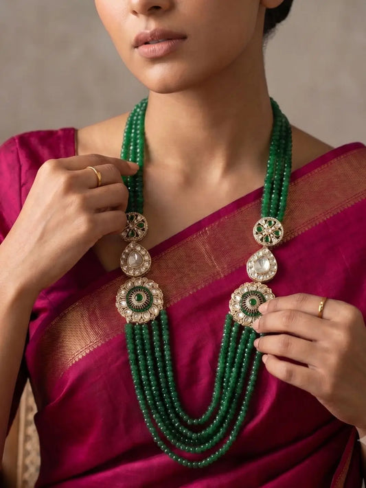 Emerald green layered necklace with natural jade beads, Kundan Polki floral brooches and gold-plated detailing for bridal and wedding styling.