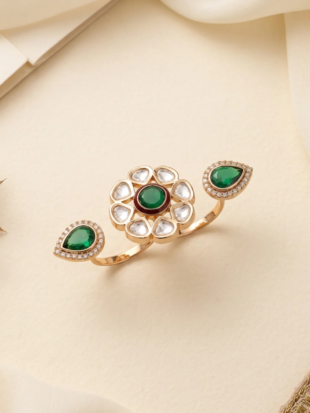 Green statement ring featuring an open dual-finger design, floral Polki detailing, CZ stones and a gold-plated setting.