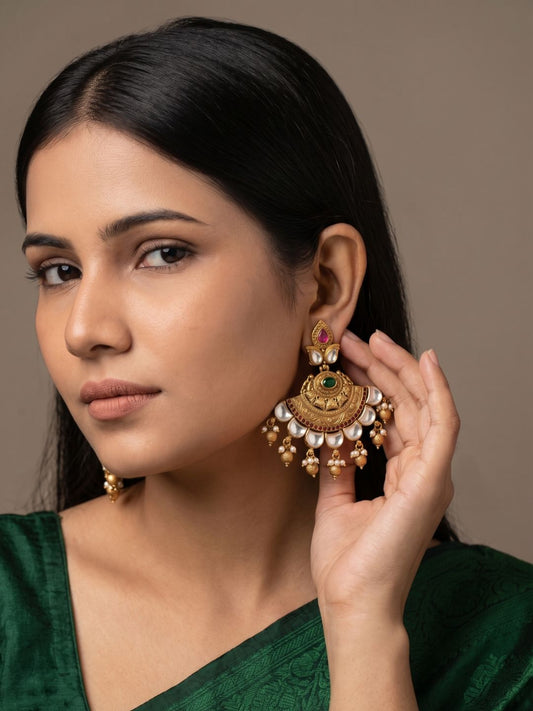 Gold-plated antique gold Chandbali earrings featuring sparkling Kundan stones, green centrepiece, ruby accents and pearl tassels