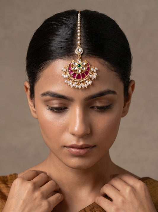 Gold-plated jadau maang tikka with ruby stones, Kundan Polki-style detailing, clustered pearl drops and a traditional bridal chain