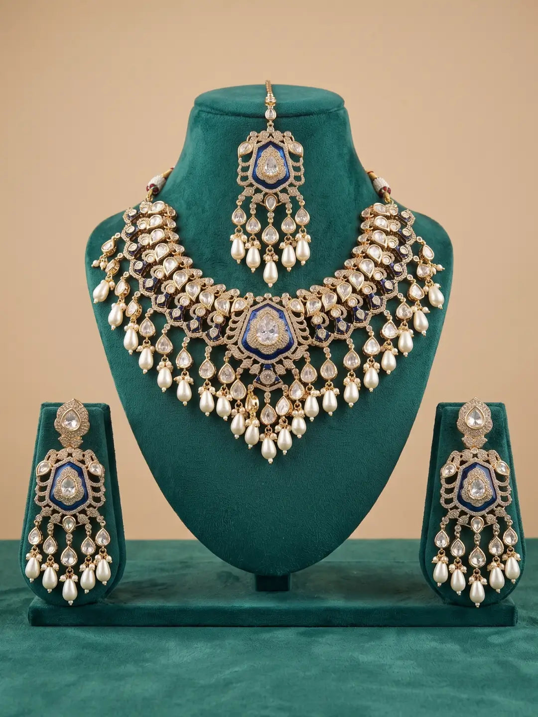 Close-up of a royal blue bridal necklace with Kundan and Polki stones, sparkling CZ accents, gold-plated brass and cascading pearl drops.
