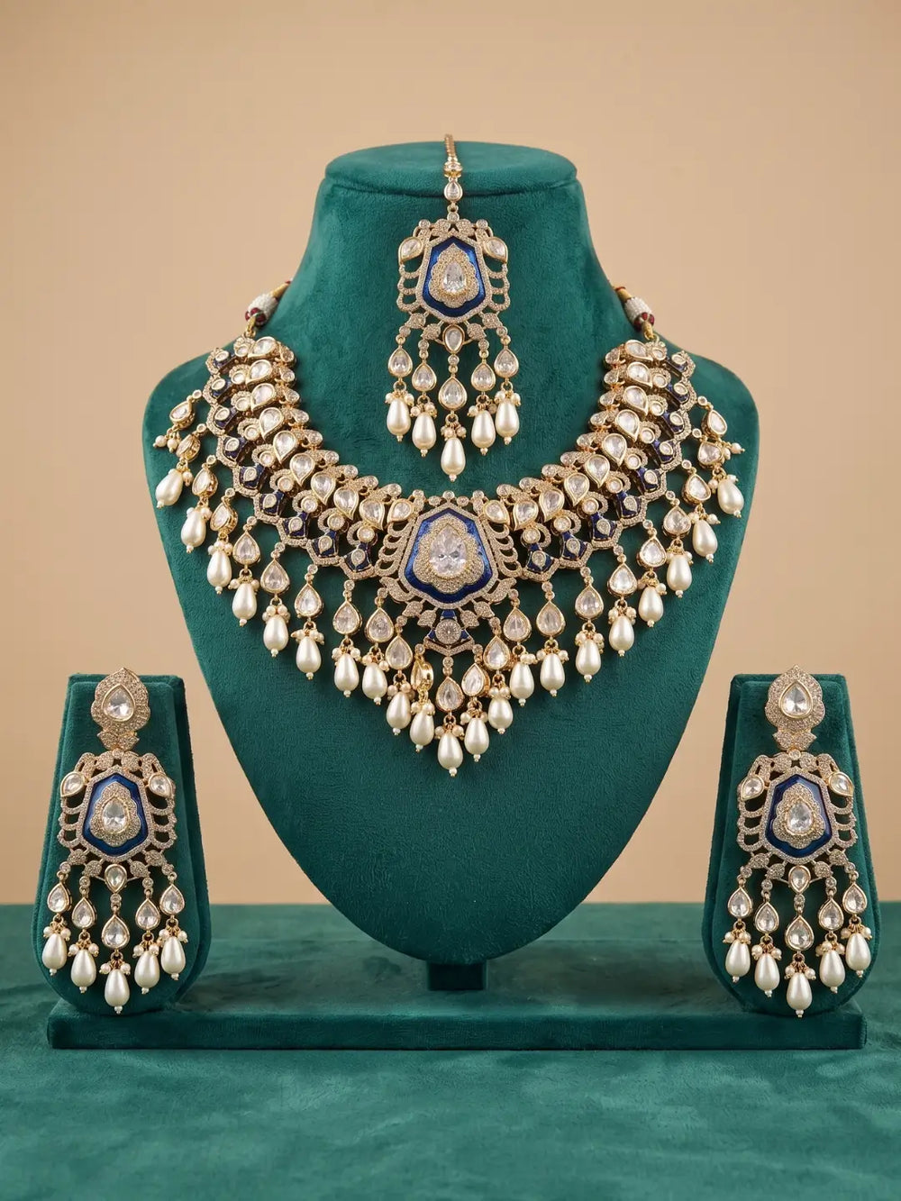 Close-up of a royal blue bridal necklace with Kundan and Polki stones, sparkling CZ accents, gold-plated brass and cascading pearl drops.