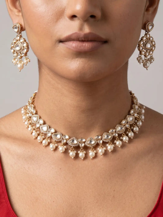 Gold plated Kundan Polki necklace with teardrop stones, delicate detailing and multiple faux pearl drops with matching earrings.