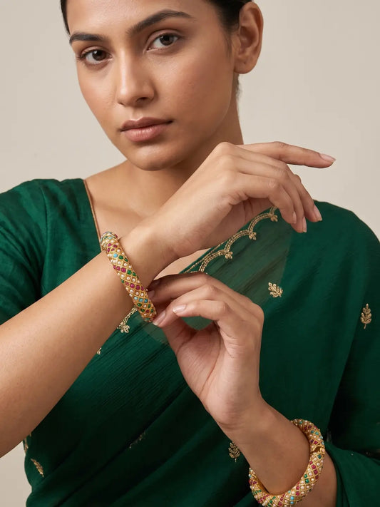 Gold plated multicolor Jadau bangles featuring turquoise blue, emerald green, deep pink and pearl-white accents in a diamond lattice design.