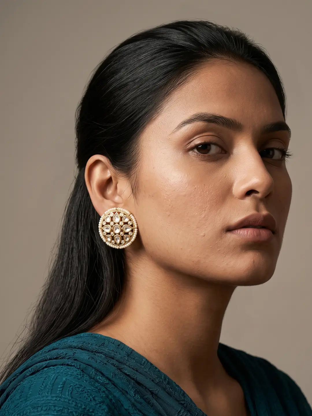 Gold plated round Kundan stud earrings framed with lustrous pearls, sparkling CZ stones and detailed Polki accents for bridal wear