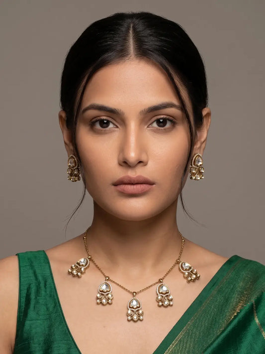 Delicate gold chain necklace featuring multiple floral Polki drops and coordinated earrings for a refined traditional-modern look.