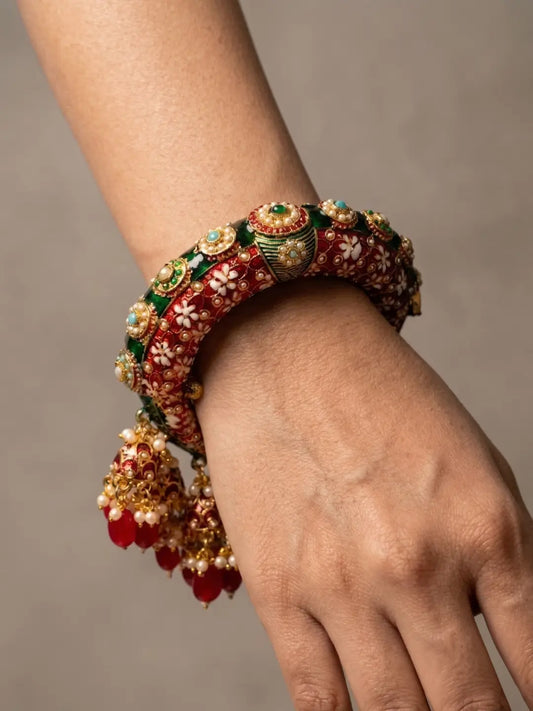Gold plated red Meenakari kada bangle featuring Kundan-style stones, synthetic pearls and floral detailing for traditional bridal styling.