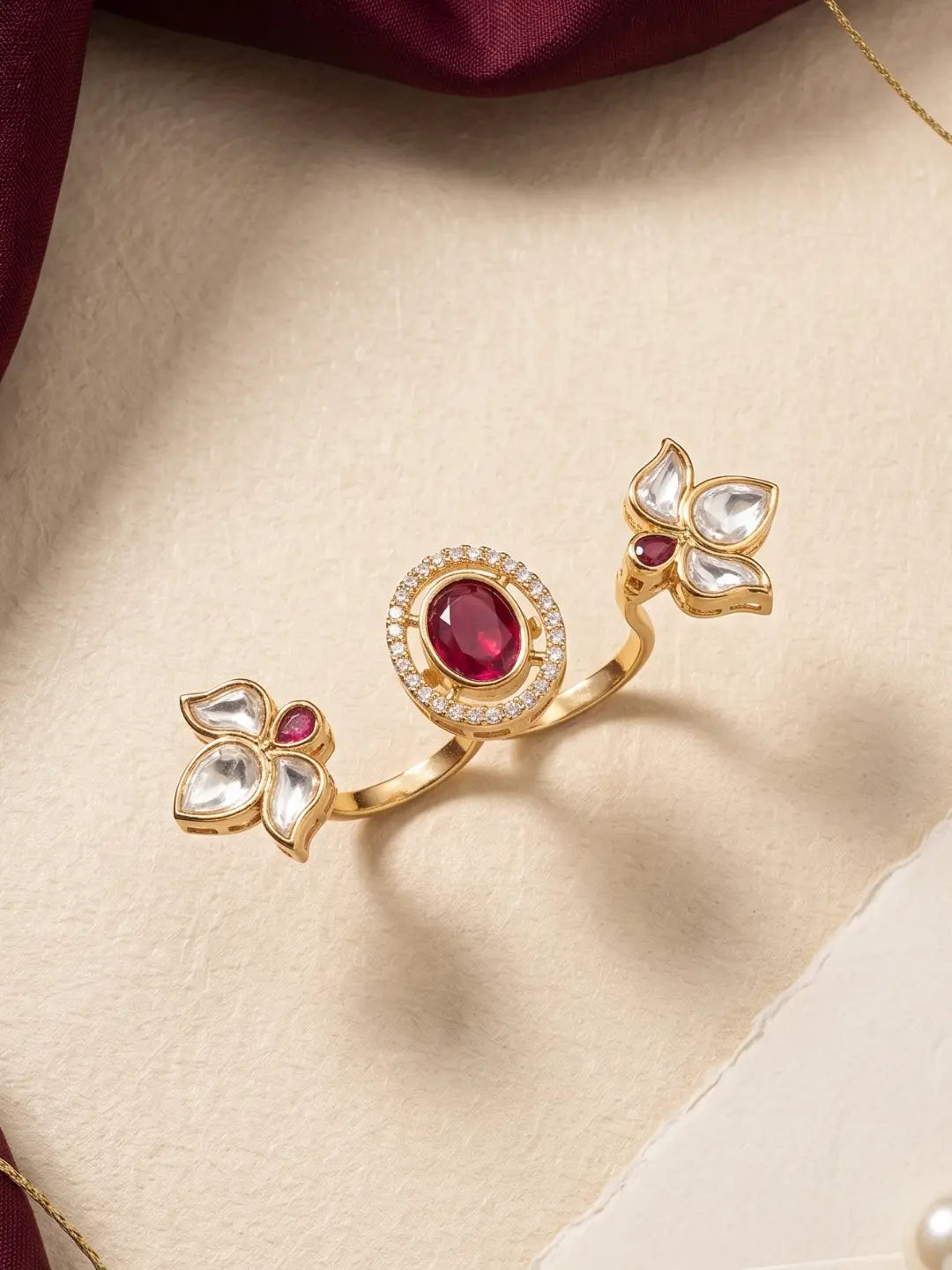 Gold plated ruby pink dual finger Polki ring with three connected floral clusters, pear-shaped details and CZ accents for weddings and cocktail parties