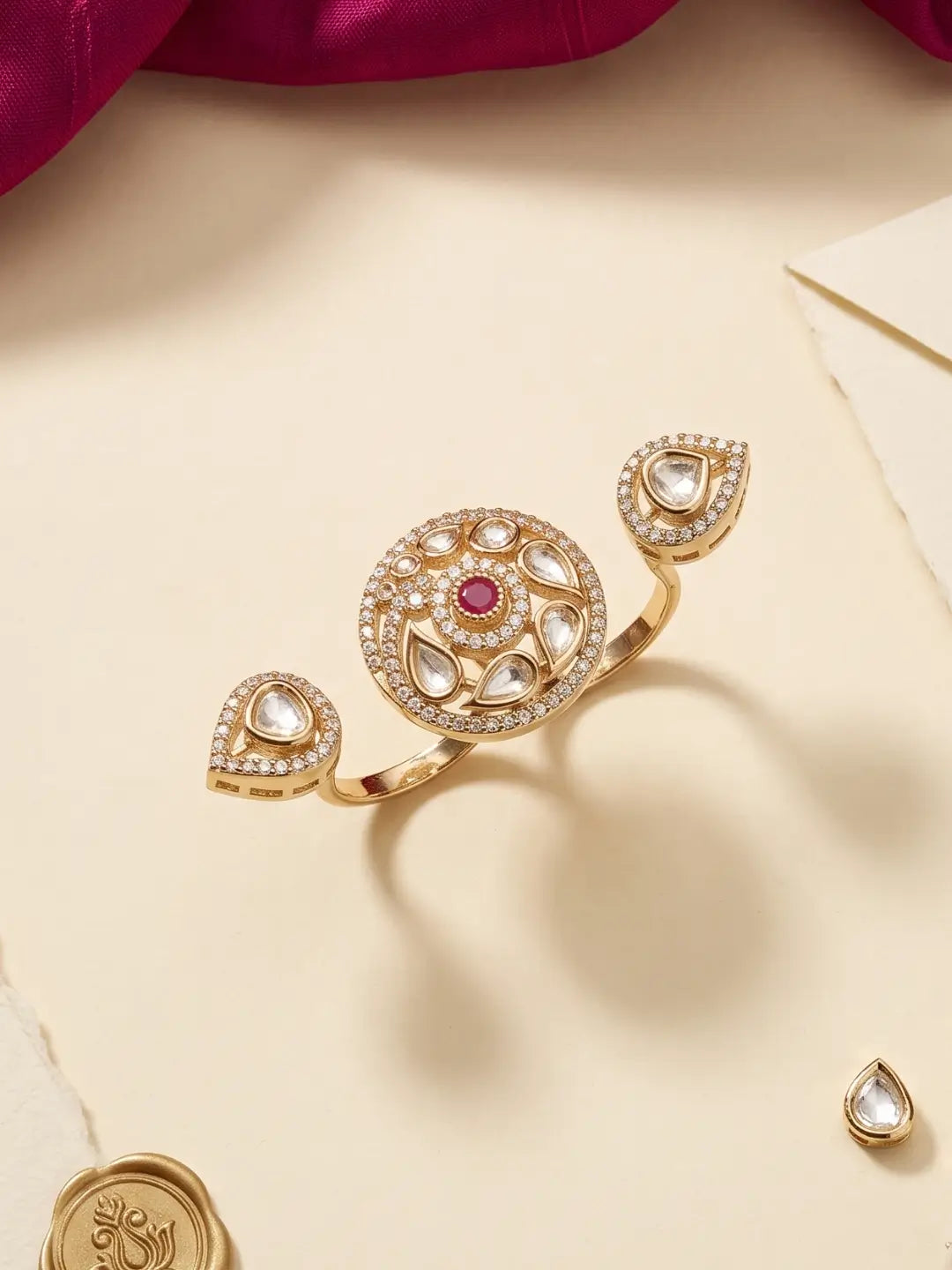 Gold plated ruby pink dual finger Polki ring featuring three connected focal elements, ornate Kundan stonework and a bold floral-inspired silhouette