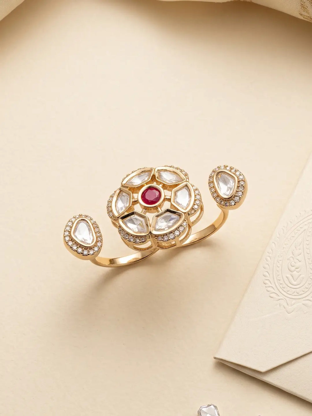 Gold plated ruby pink dual finger Polki ring featuring three connected focal elements, ornate stone clusters and a bold silhouette for wedding outfits