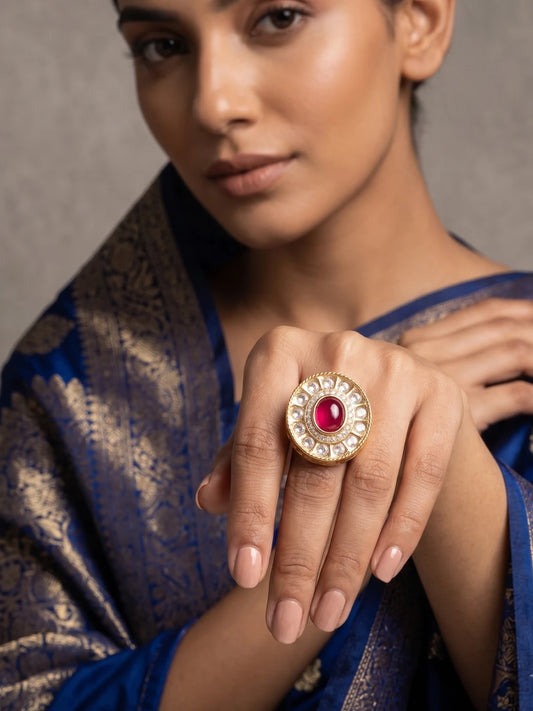 Gold plated ruby pink Kundan Polki ring featuring an ornate oval design, sparkling stone accents and adjustable fit for sarees and lehengas