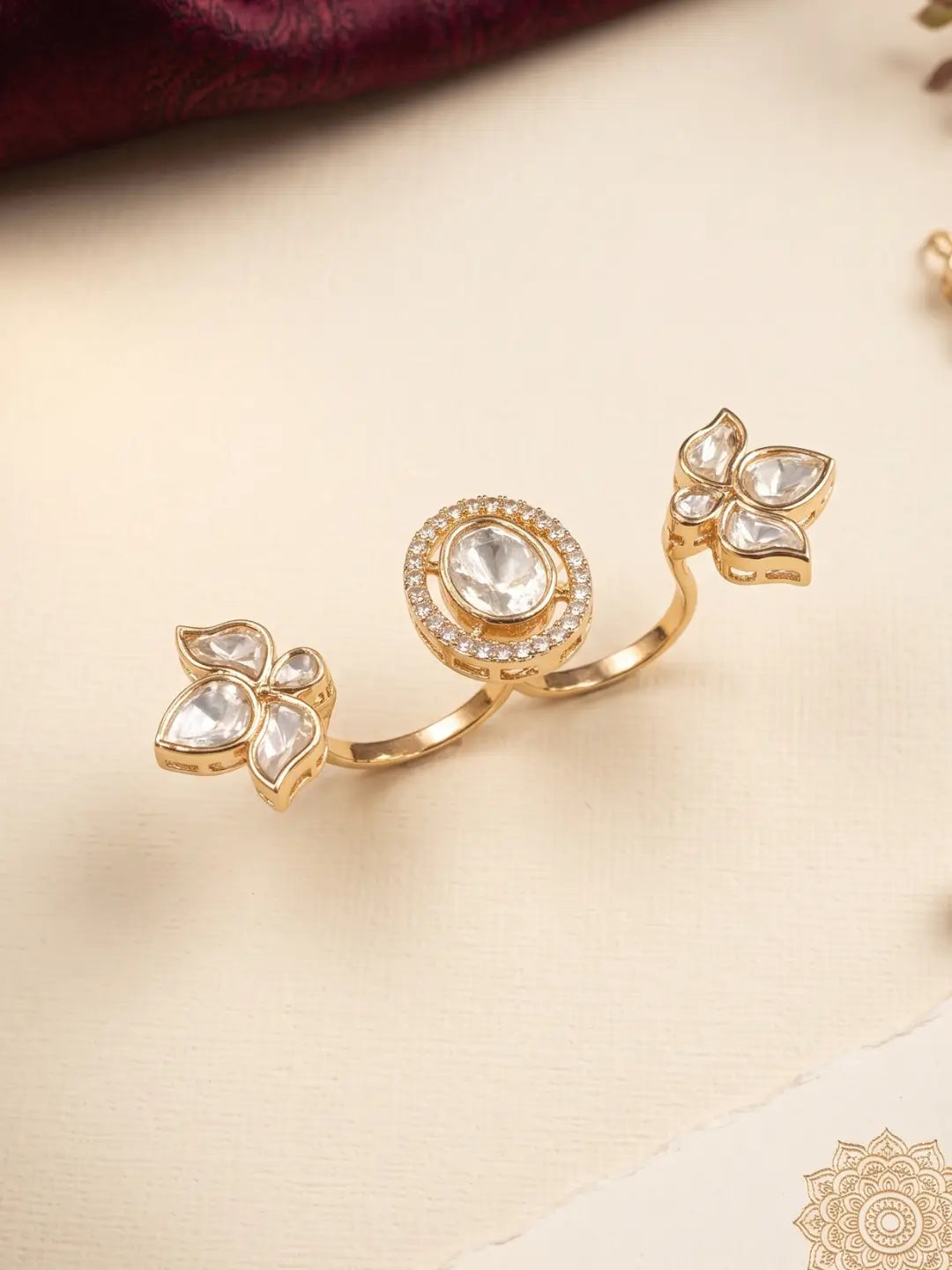 Gold plated white Polki dual finger statement ring with connected floral stonework, a round centre and sparkling CZ details for saree and lehenga looks