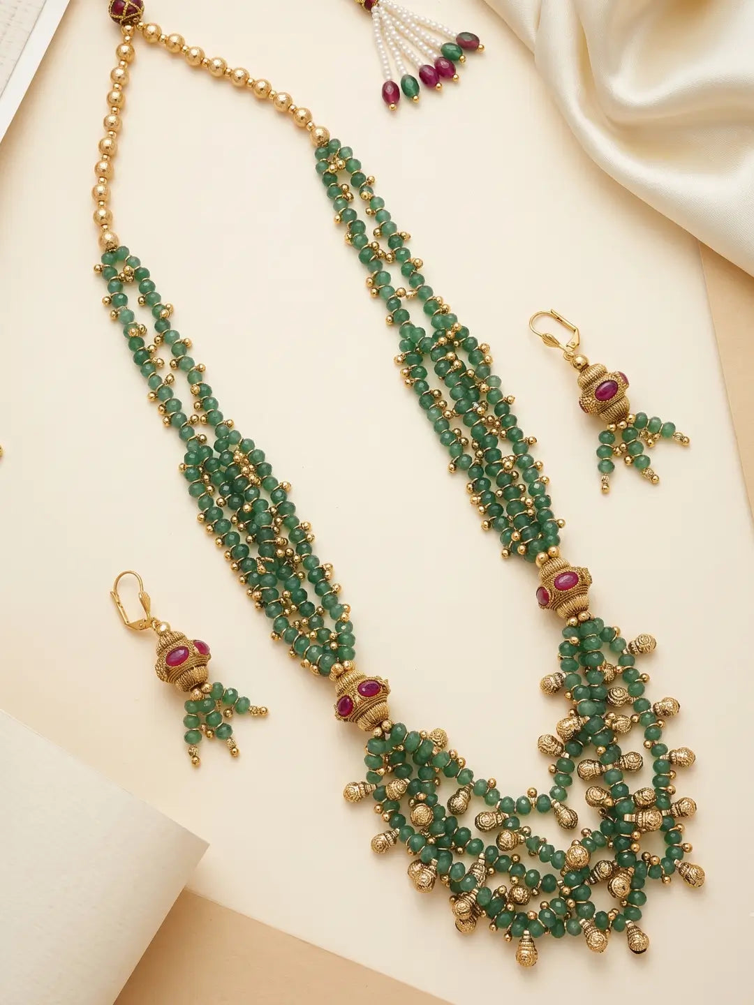 Gold tone green beaded ethnic necklace with layered jade beads, decorative golden accents and coordinated earrings with pink stone details