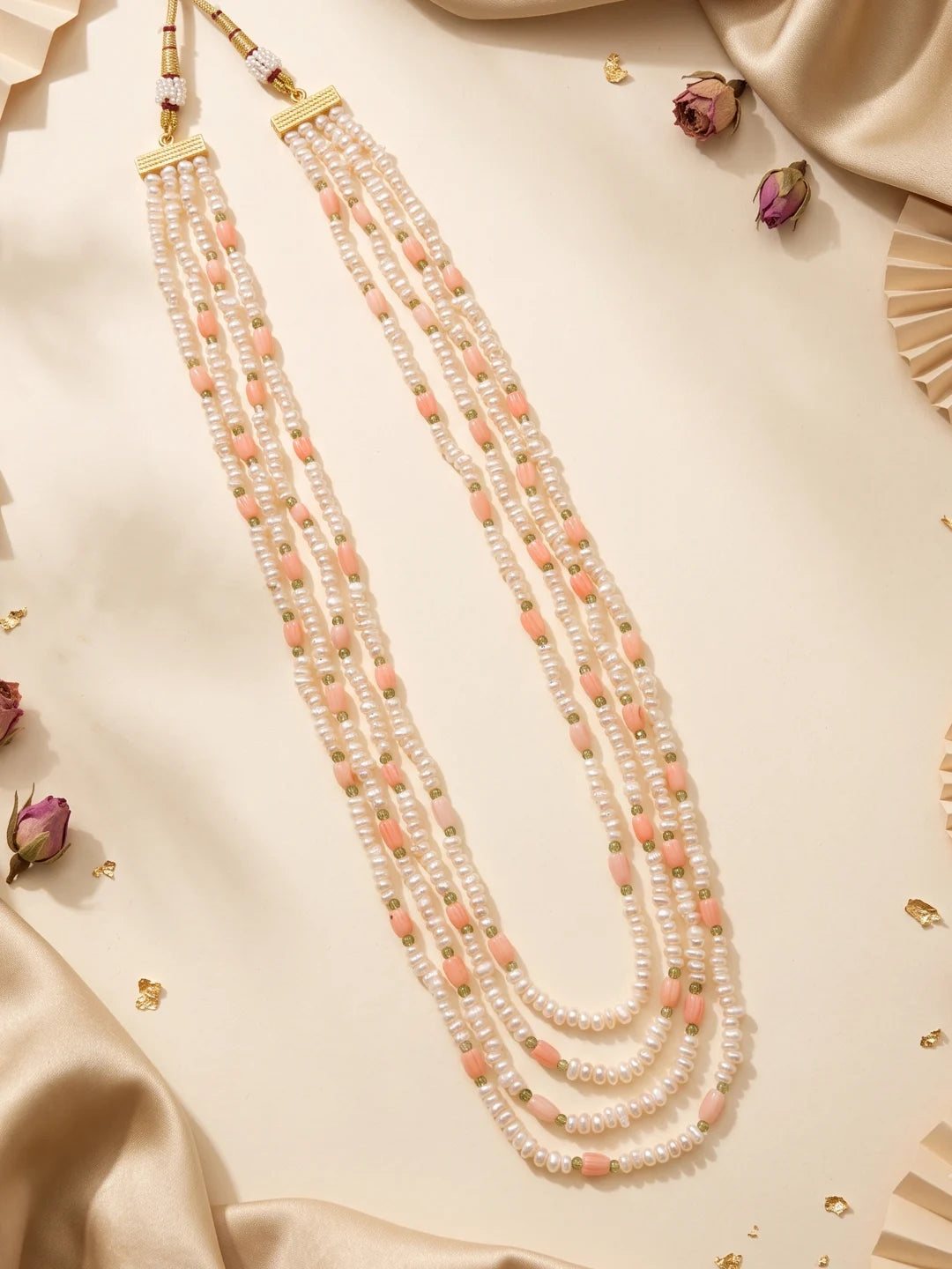 Graduated pearl and tulip bead strands with the adjustable dori closure of a gold-plated brass alloy necklace, showing the layered drape and length