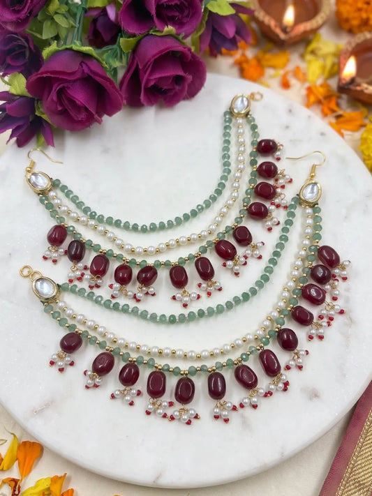 Green beaded bridal ear chain with pearl strands, maroon accents and Kundan detail for traditional wedding hairstyles.