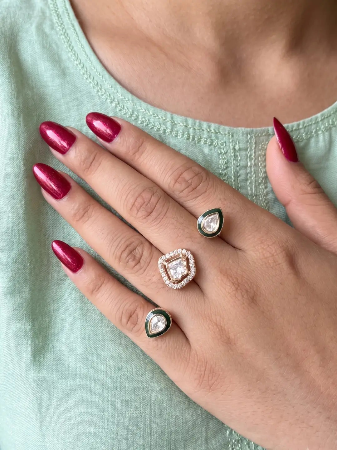 Green CZ Polki dual finger ring with two gold-tone bands, connected stone elements and enamel detailing for bridal, wedding and festive styling