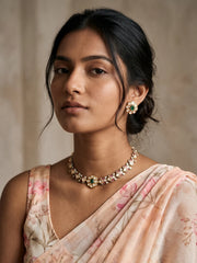 Green floral Polki necklace featuring dual-tone motifs, clear CZ accents, enamel detailing and matching stud earrings.