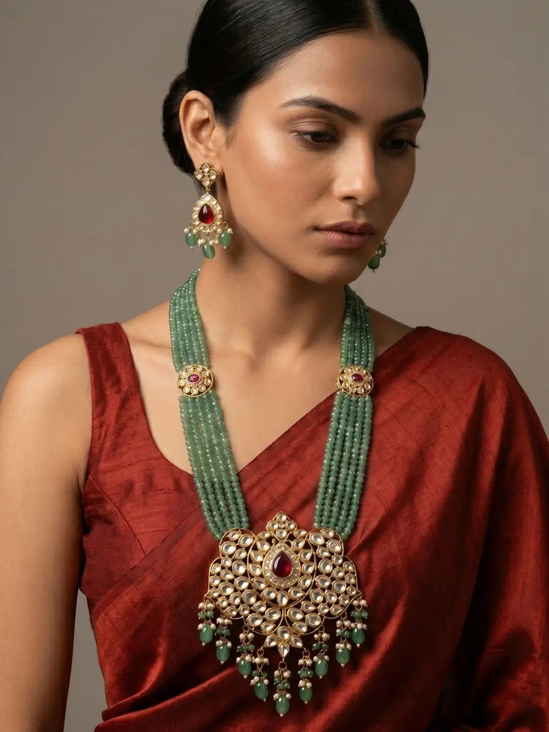 Green beaded kundan necklace with pendant and jhumka earrings, suited to styling with silk sarees, lehengas and festive ethnic wear for weddings