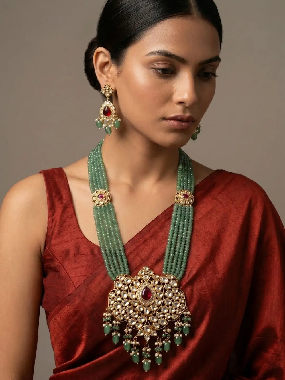 Green beaded kundan necklace with pendant and jhumka earrings, suited to styling with silk sarees, lehengas and festive ethnic wear for weddings